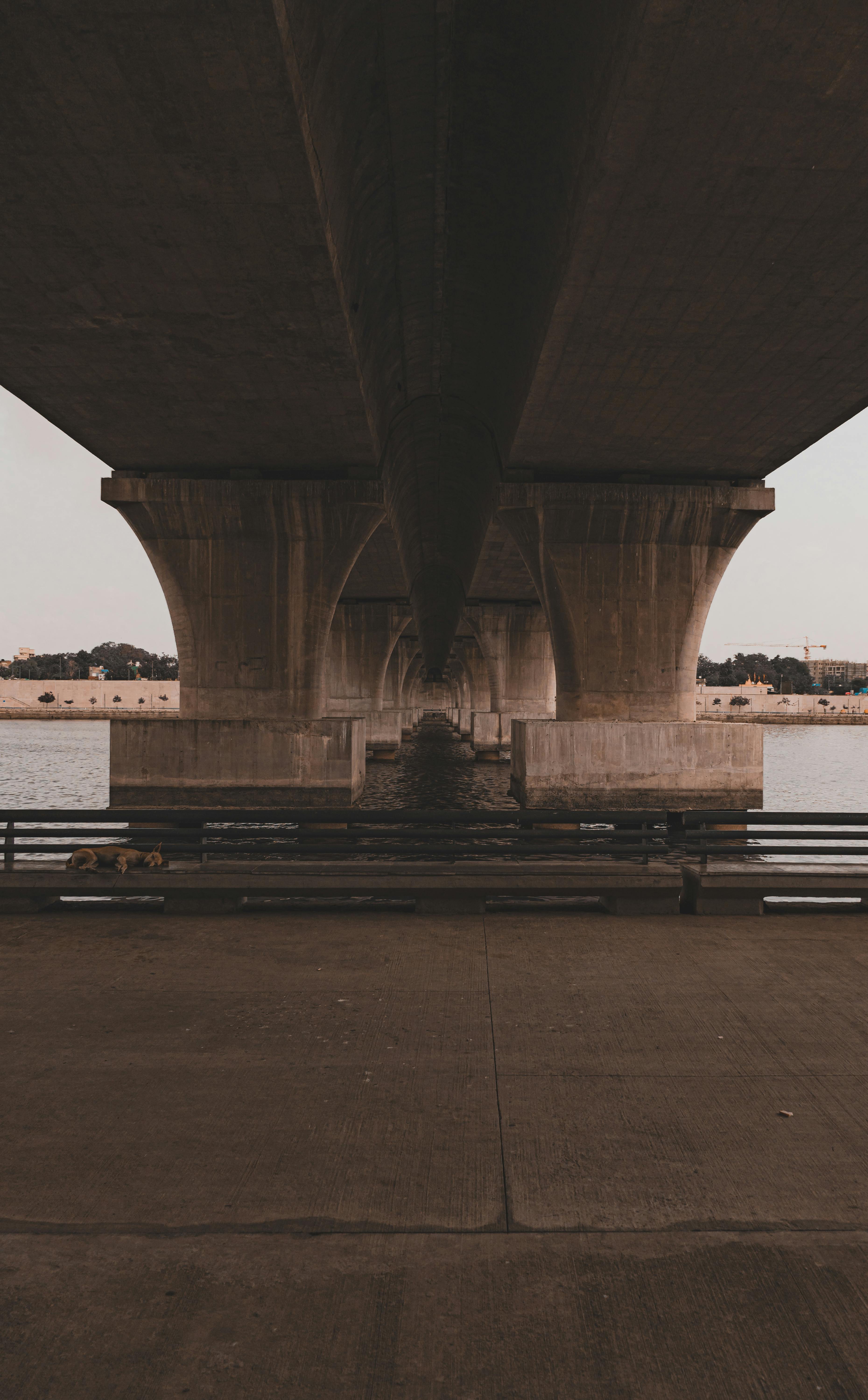 Grey Concrete Bridge Above Water Under Blue Sky · Free Stock Photo