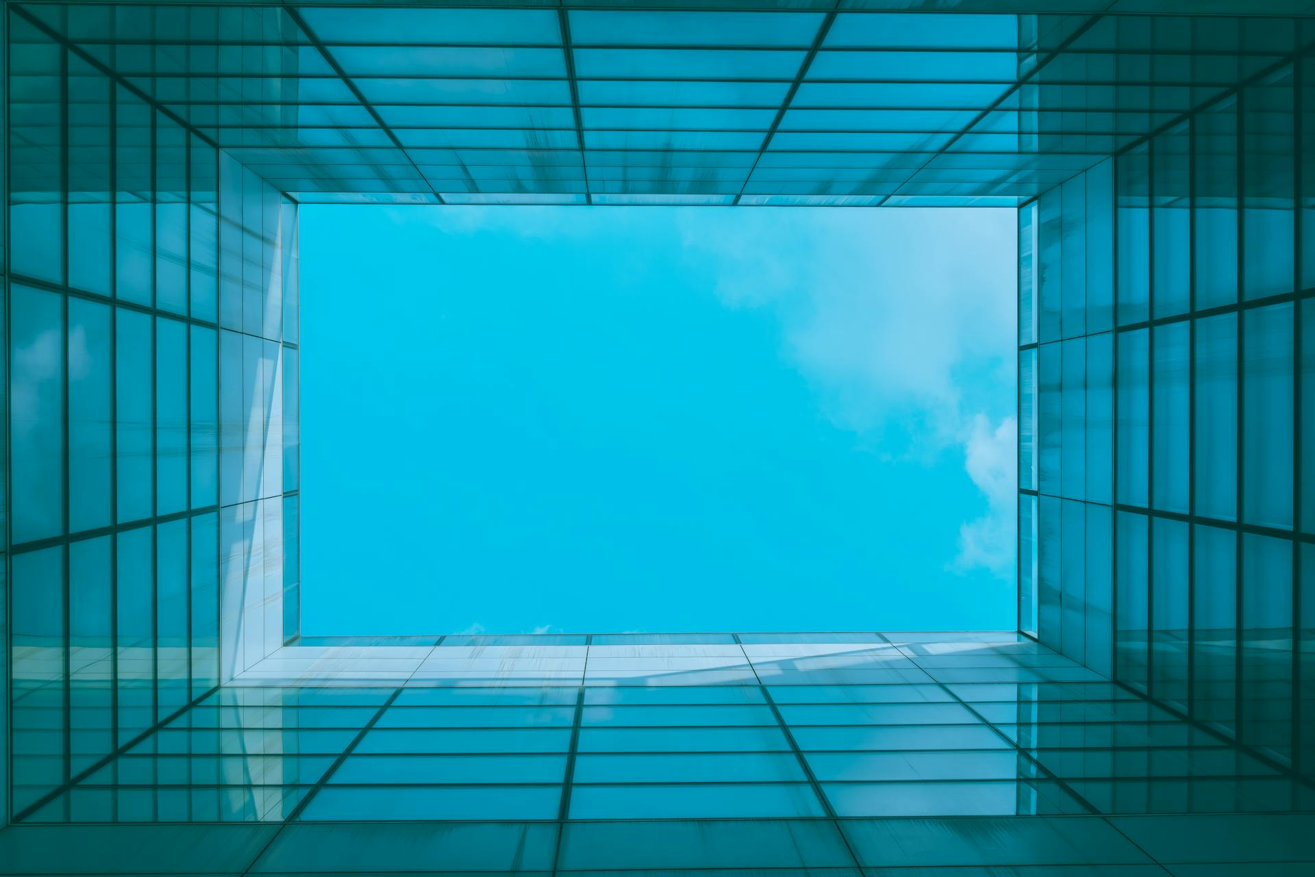 A stunning view of the blue sky through a modern architectural skylight with geometric patterns.