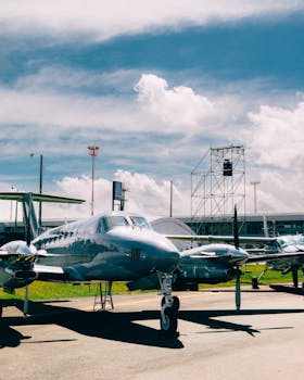 Small propeller planes on a grass airstrip under a clear blue sky, ideal for aviation themes.