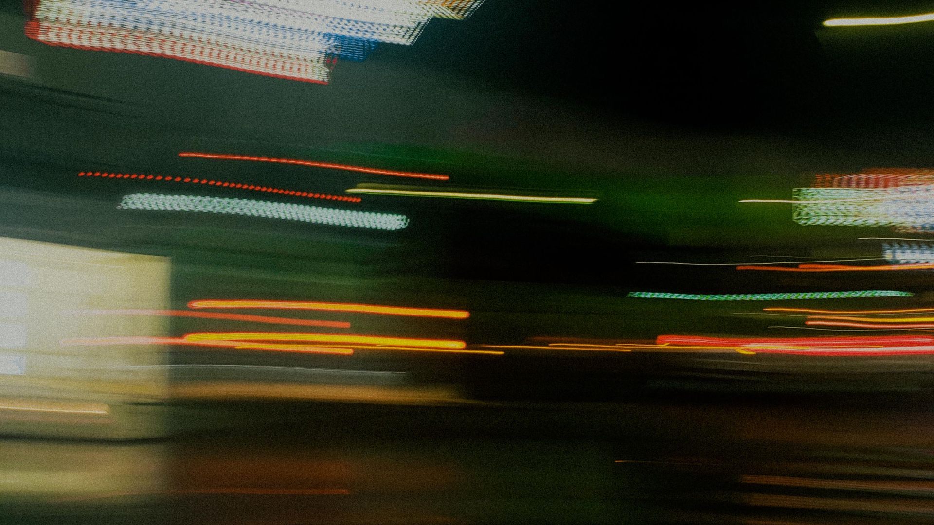 Blurred motion of colorful lights creating abstract patterns on Madrid streets at night.