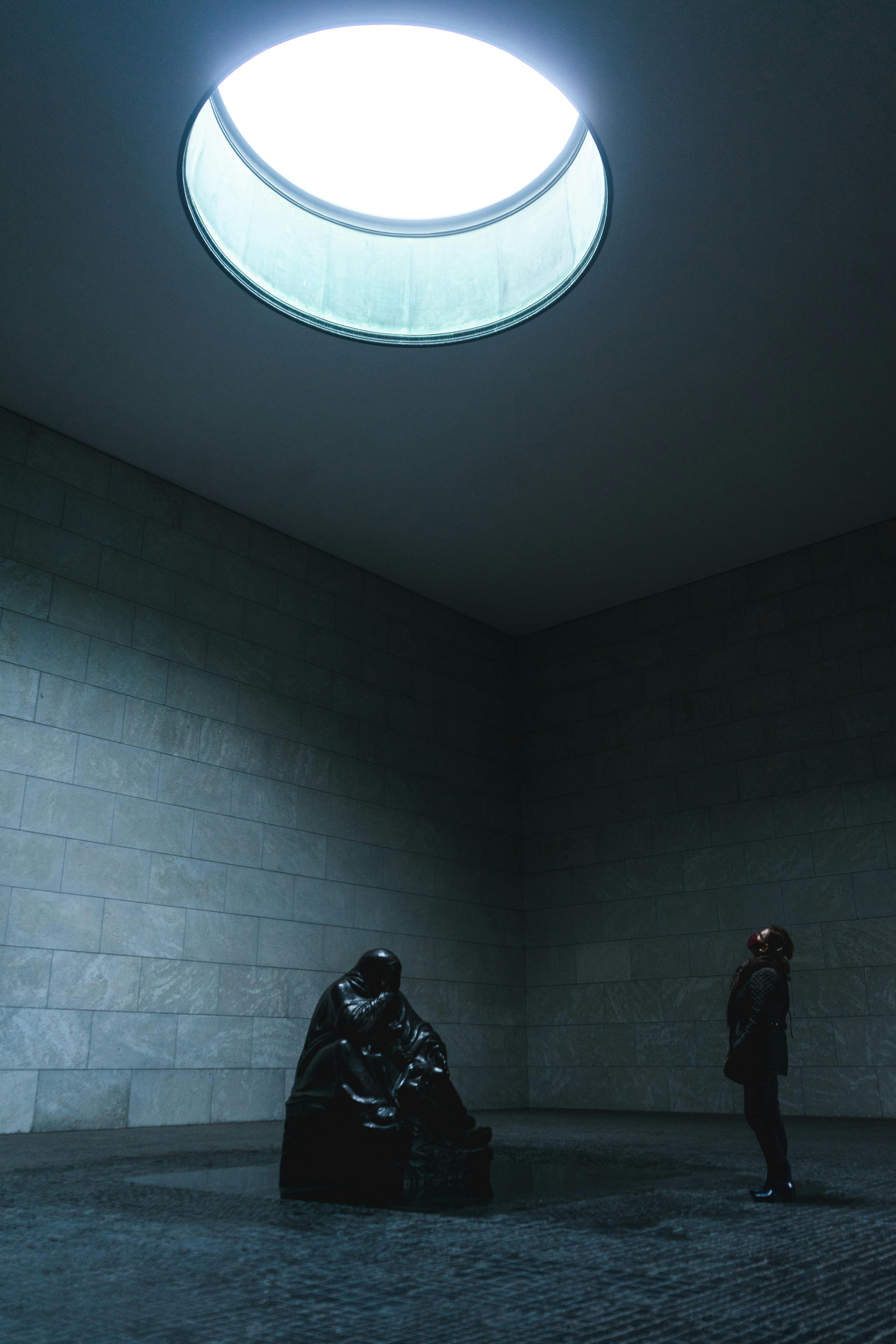 Interior view of Neue Wache in Berlin, showcasing a monumental sculpture under a skylight.