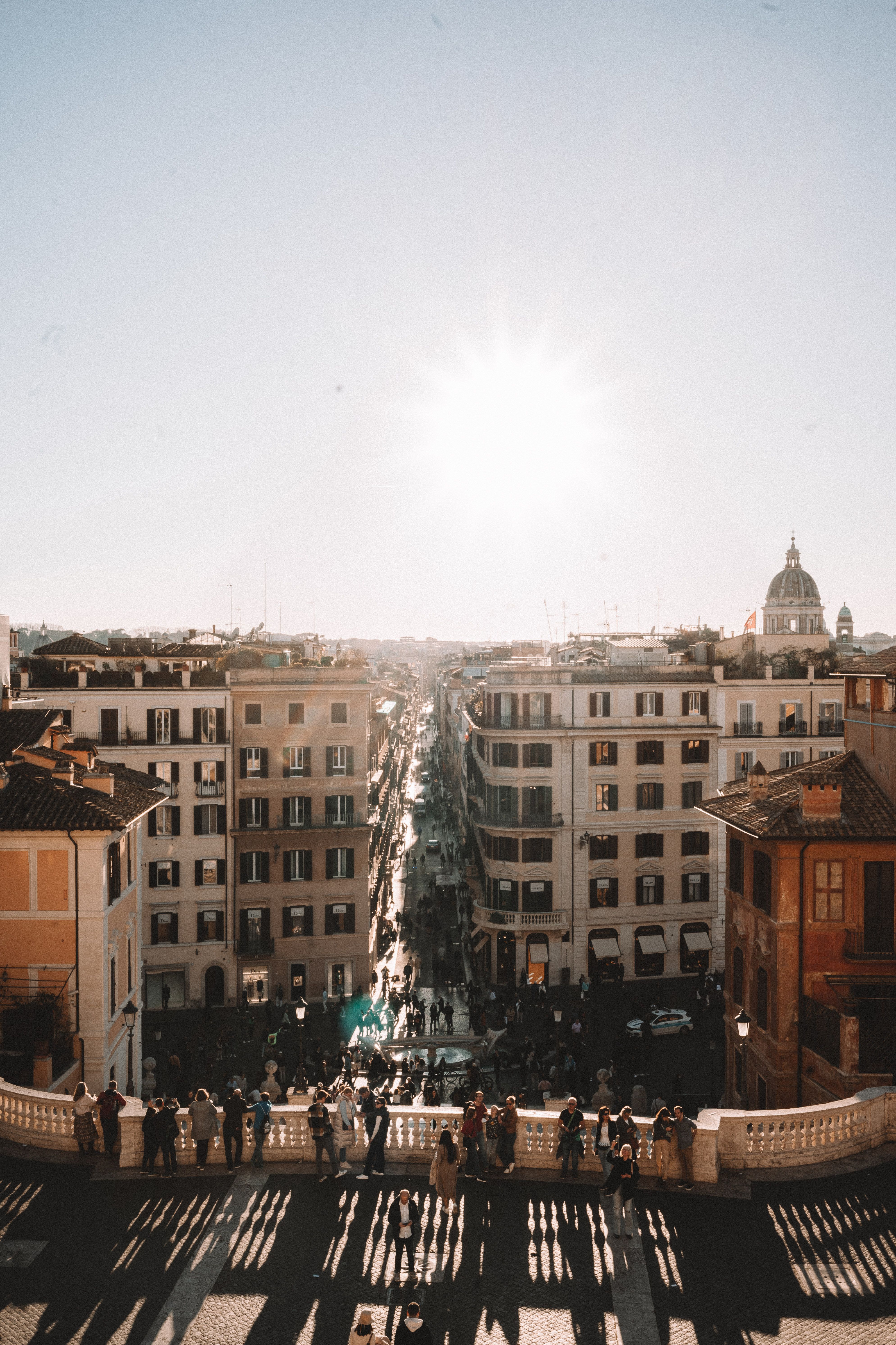 Aerial view of Rome with historical buildings and sunlight, capturing urban beauty in Italia.