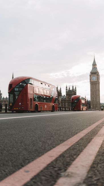 Red double-decker buses on Westminster Bridge with Big Ben in the background, London.
