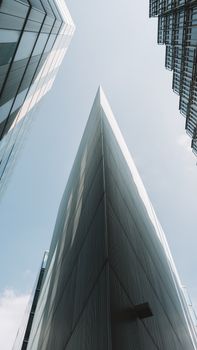 Impressive modern skyscrapers viewed from low angle against a clear sky.