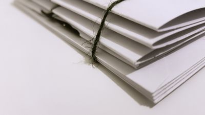 Bundle of documents tied with string — photo by Sam J on Pexels