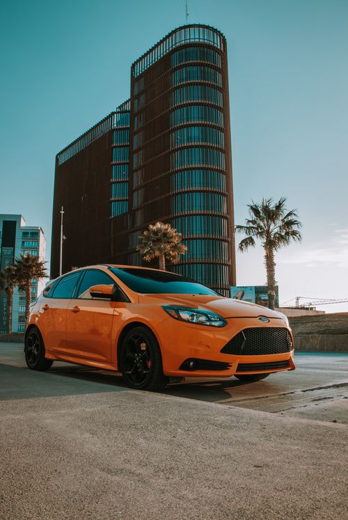 Free Vibrant yellow car parked with modern architecture backdrop in San Luis Potosí, Mexico. Stock Photo