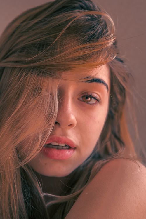 Free Artistic close-up portrait of a blonde woman with expressive eyes and long hair. Stock Photo