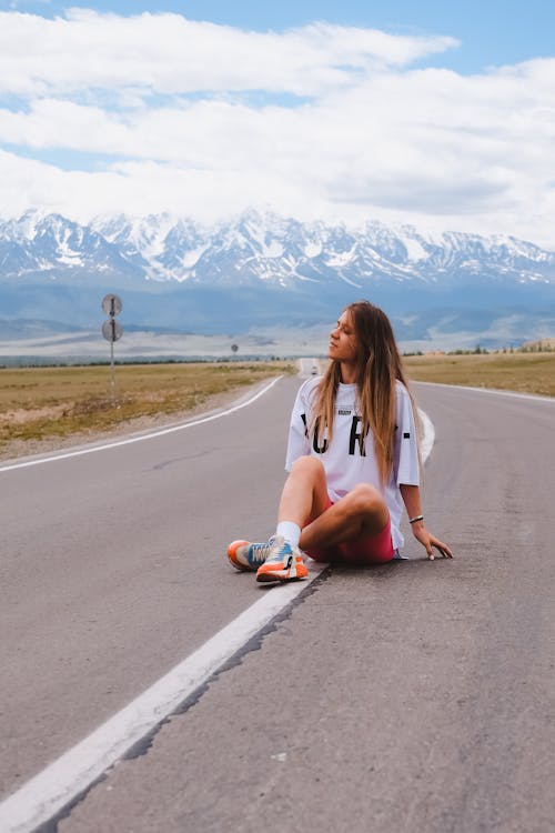 Woman Sitting on Road in Countryside