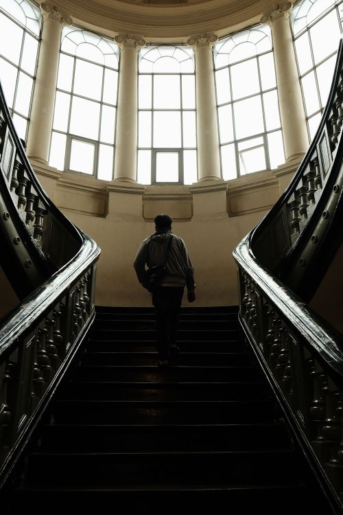 Free A person ascending elegant stairs inside the Museum of Ho Chi Minh City, showcasing classic architecture. Stock Photo