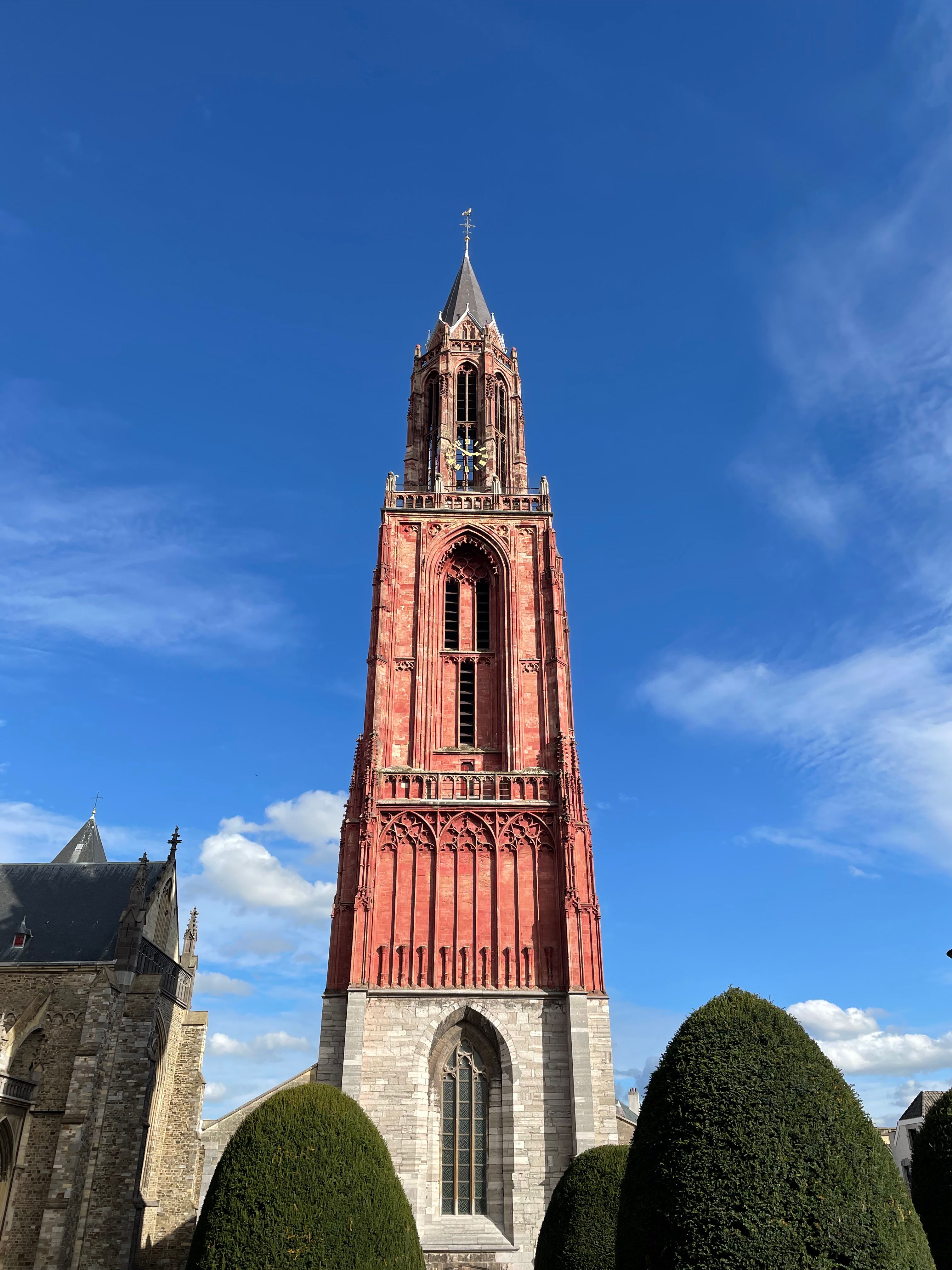 A stunning view of the Saint Jan Church Tower against a clear blue sky in Maastricht, Netherlands.