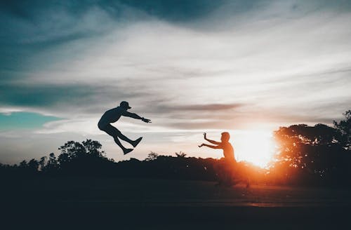 gratis Persoon Voor Man Flying Dragen Hoed Tijdens Zonsondergang Stockfoto