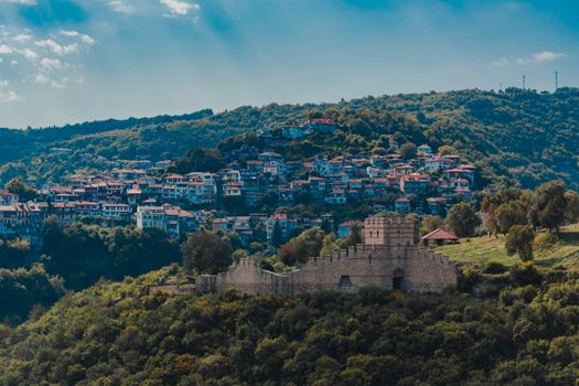 A stunning aerial view of Veliko Tarnovo, Bulgaria, showcasing a historic fortress and vibrant hillside houses.