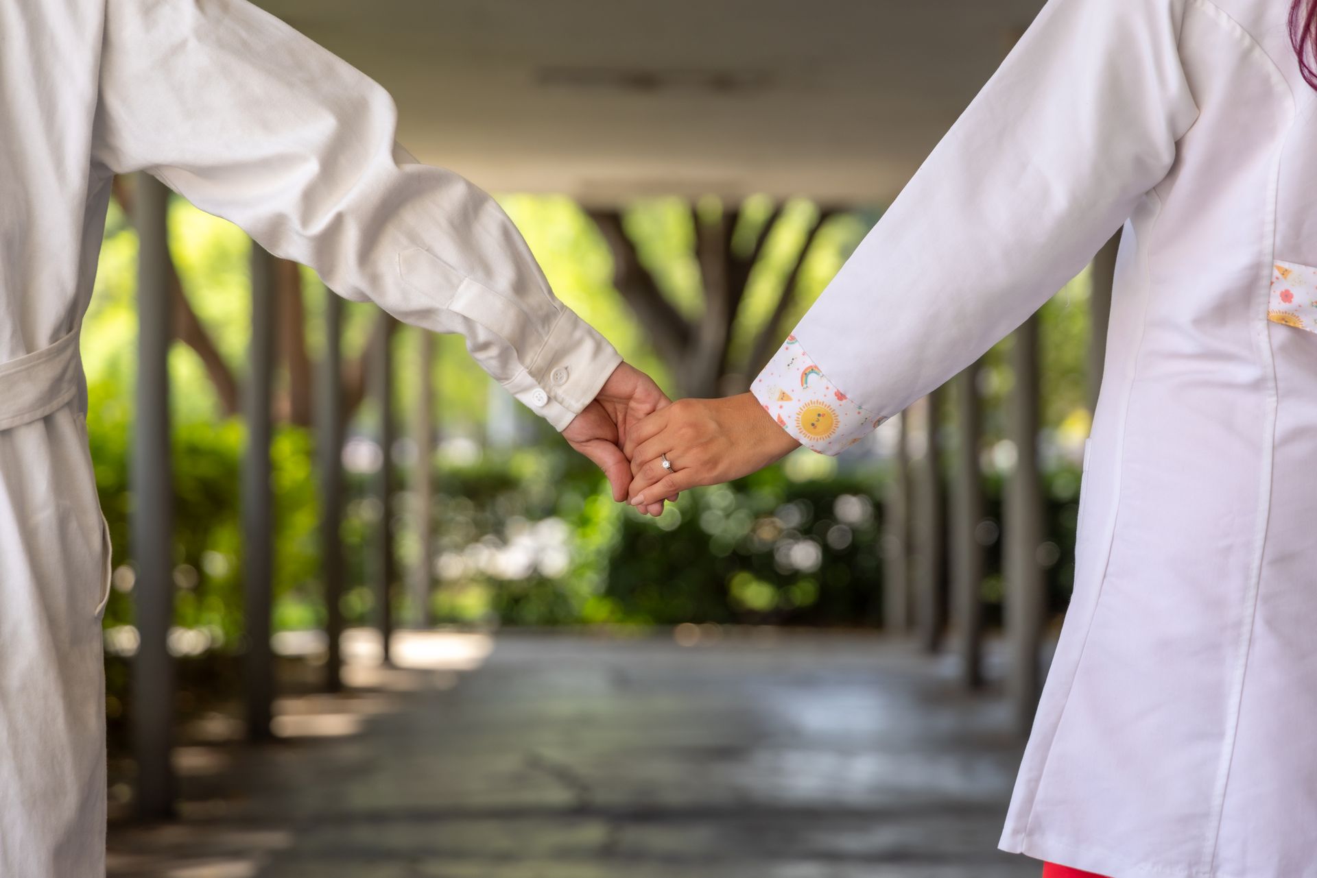 Scientists in lab coats holding hands, symbolizing unity and collaboration.