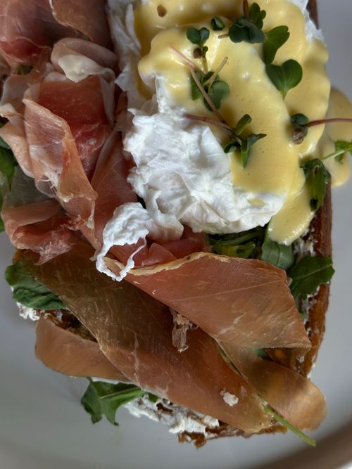 Free Gourmet sandwich with prosciutto, poached egg, and hollandaise sauce. Perfect for brunch lovers. Stock Photo
