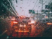 透过被雨水淋湿的挡风玻璃，可以看见模糊的城市交通，捕捉到潮湿天气中那变幻莫测的气氛