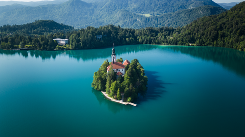Free A breathtaking aerial view of Bled Island and its church in Slovenia, surrounded by vibrant blue waters. Stock Photo