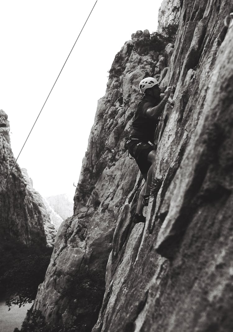 Man Climbing On Horizontal Rock