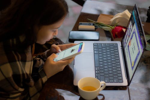 Woman Sitting with Cellphone and Laptop