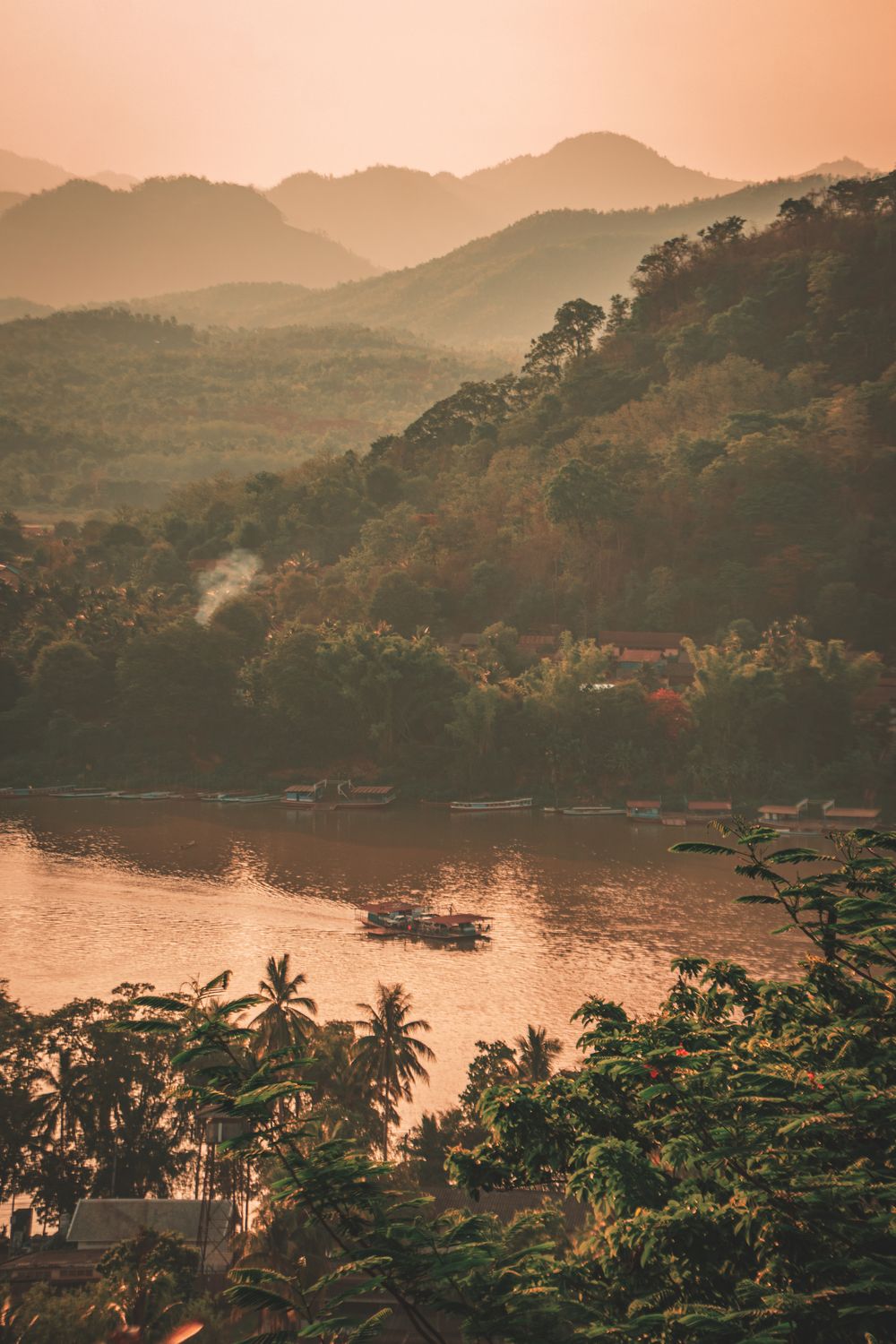 Golden sunset over the Mekong River and lush forested hills in Luang Prabang, Laos