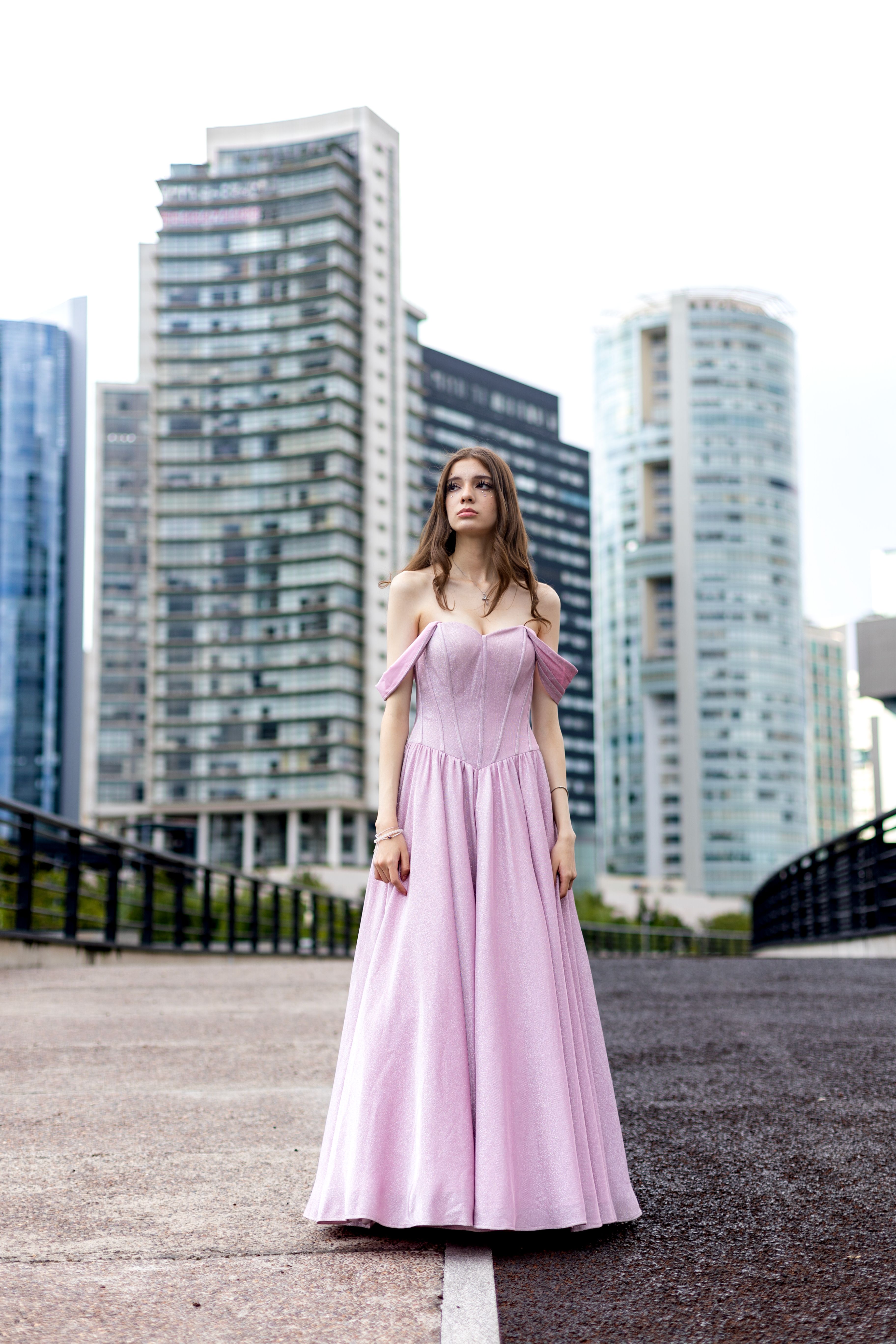 A woman in a pink dress stands in front of tall buildings · Free Stock ...