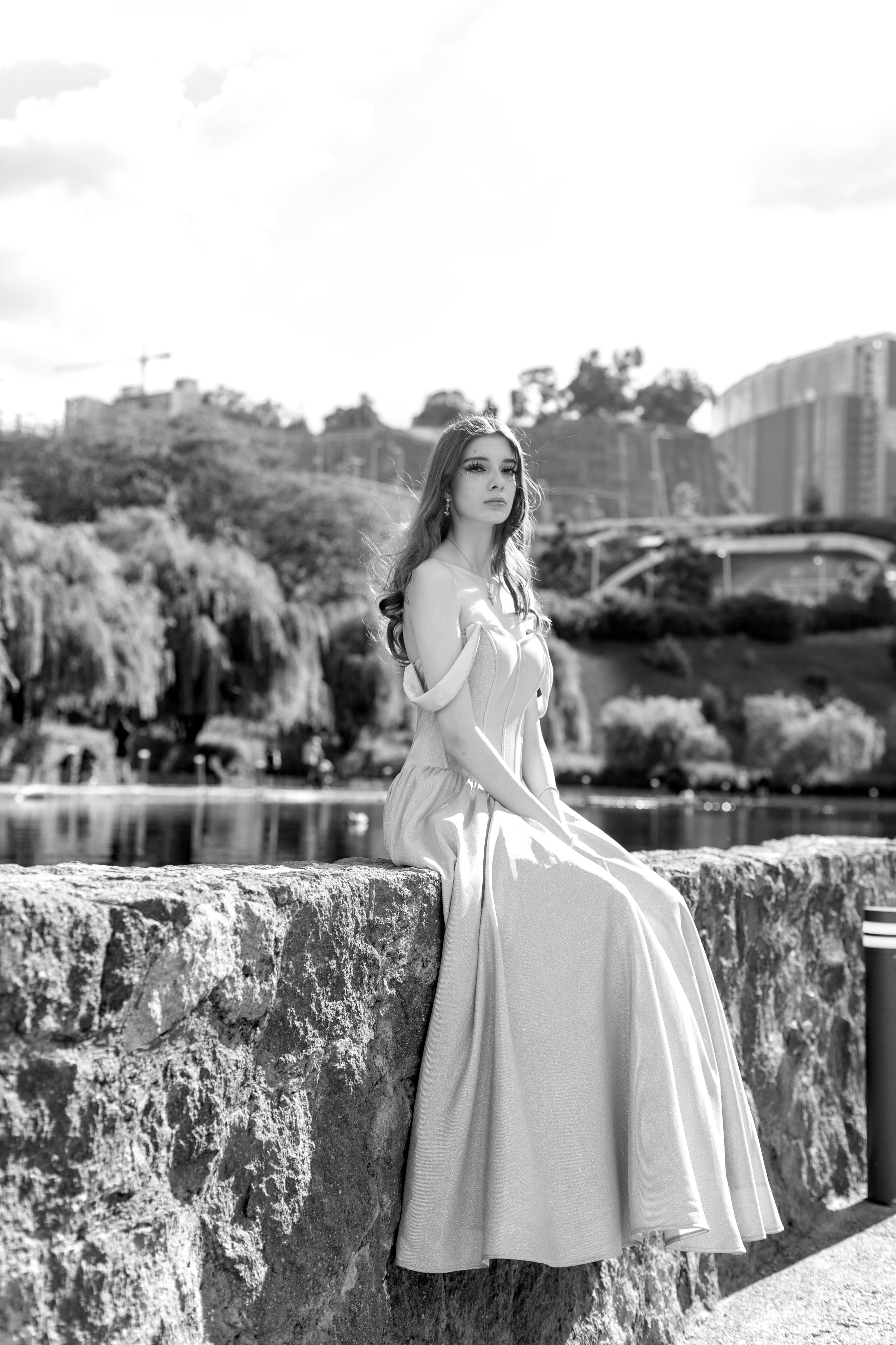 A woman in a long dress sitting on a ledge  Free Stock Photo
