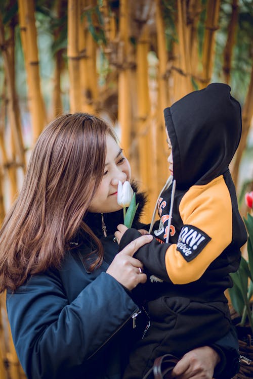 彼の手に白い花と幼児を運ぶ女性