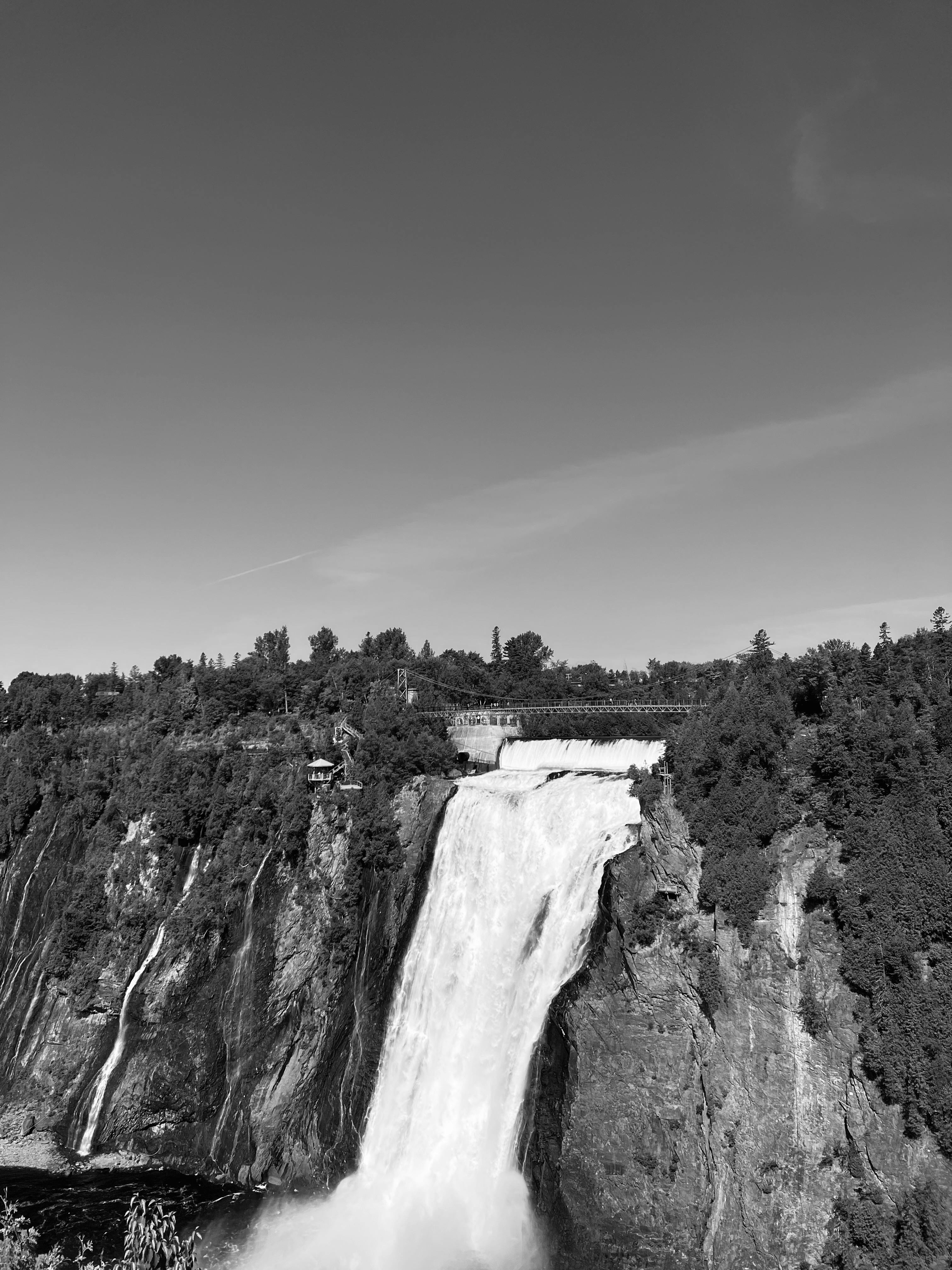 Stunning black and white photo of a majestic waterfall surrounded by nature.