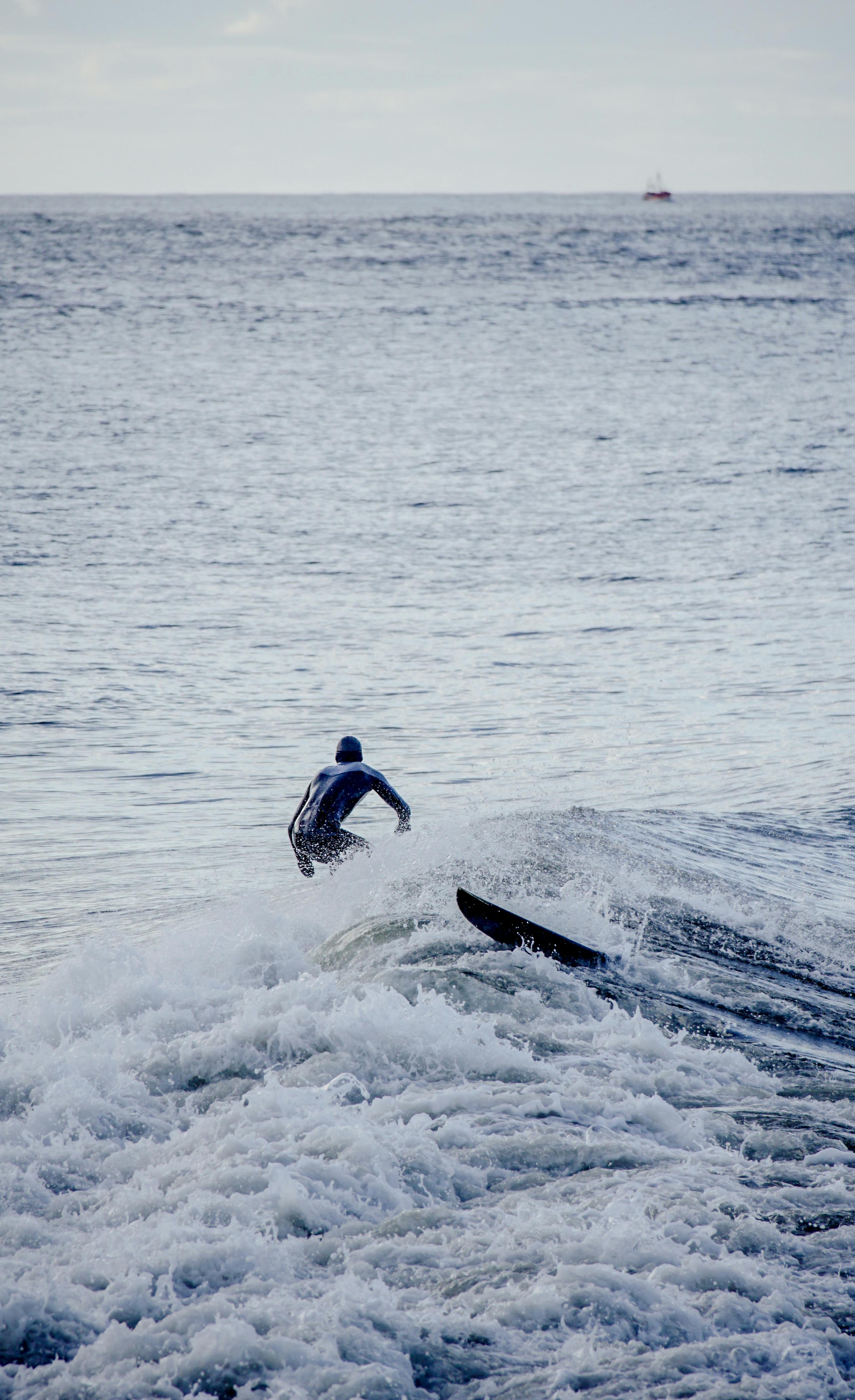 A surfer skillfully rides a wave in the vast ocean, showcasing water sports and adventure.