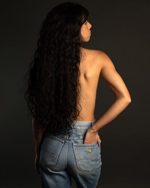 Shirtless Brunette Woman Holding Hand in Back Pocket of Jeans