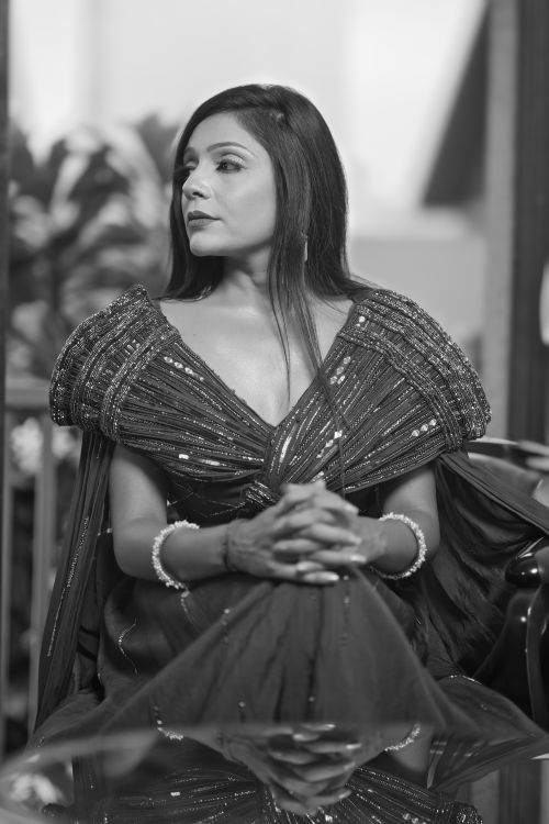 Free Black and white portrait of a woman in an elegant dress, seated indoors, showcasing fashion and grace. Stock Photo