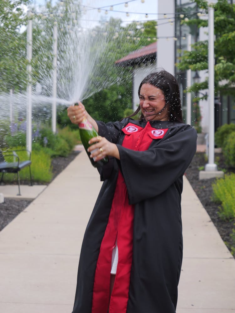 Graduate In Gown Opening Champagne