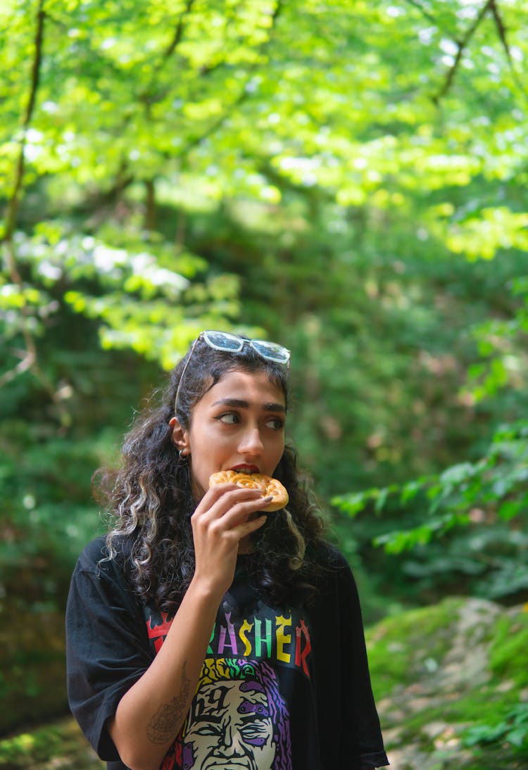 Brunette Woman Eating Food In Forest