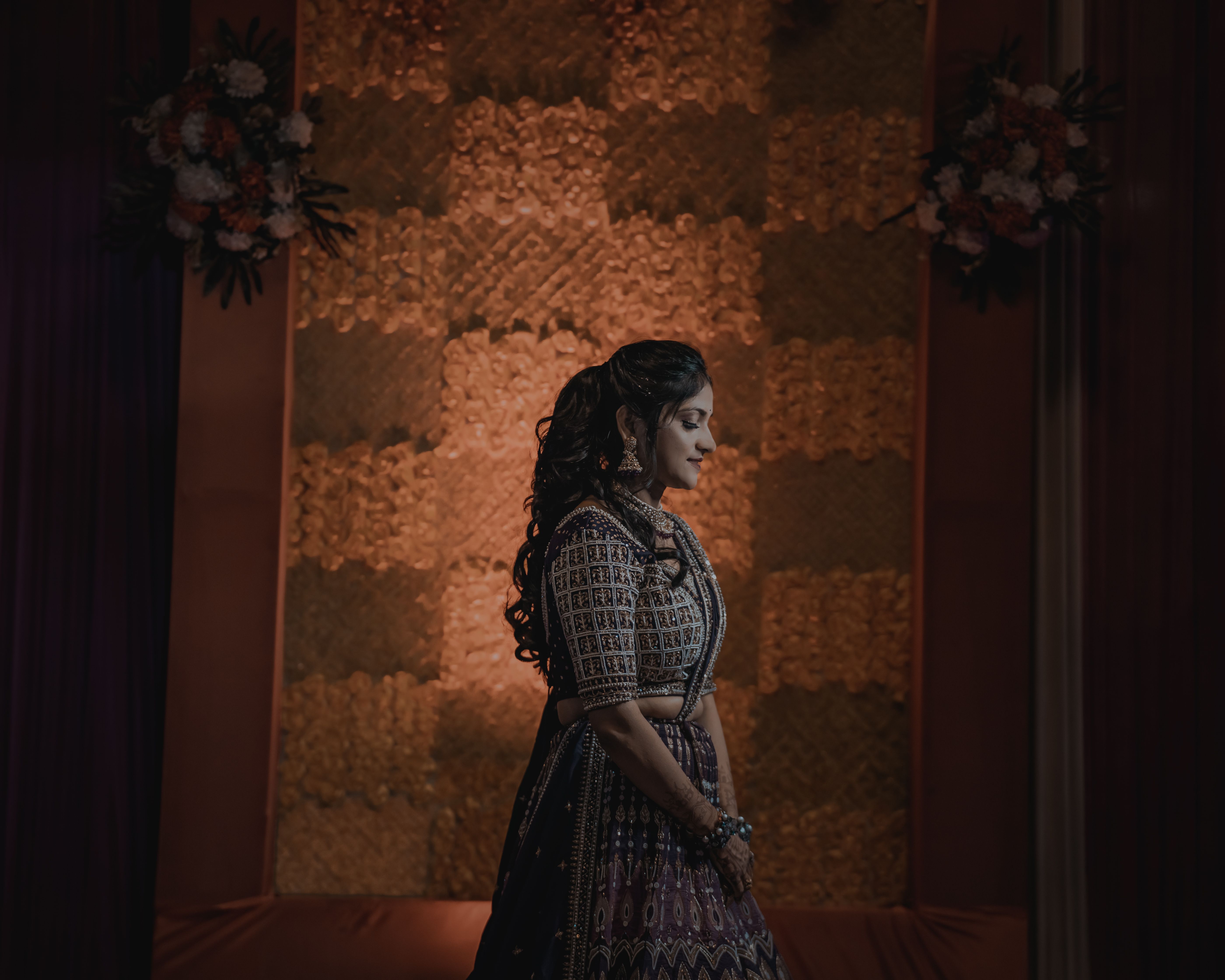 Beautiful woman in traditional Indian clothing posing indoors with elegant decor.