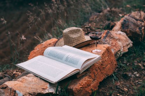Free A tranquil outdoor setting with an open book, hat, and wineglass on rocks in rural Oax., México. Stock Photo