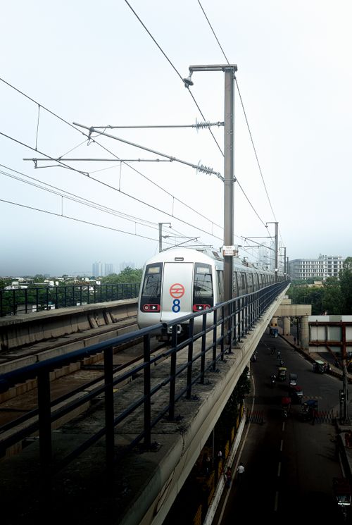 Free Metro train on elevated track in Noida, India, showcasing urban transportation. Stock Photo