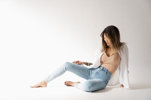 Woman Sitting and Posing in Shirt and Jeans