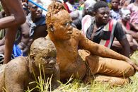 Vibrant cultural ceremony in Lama-Kara, Togo, featuring mud-covered participants enjoying the festival.