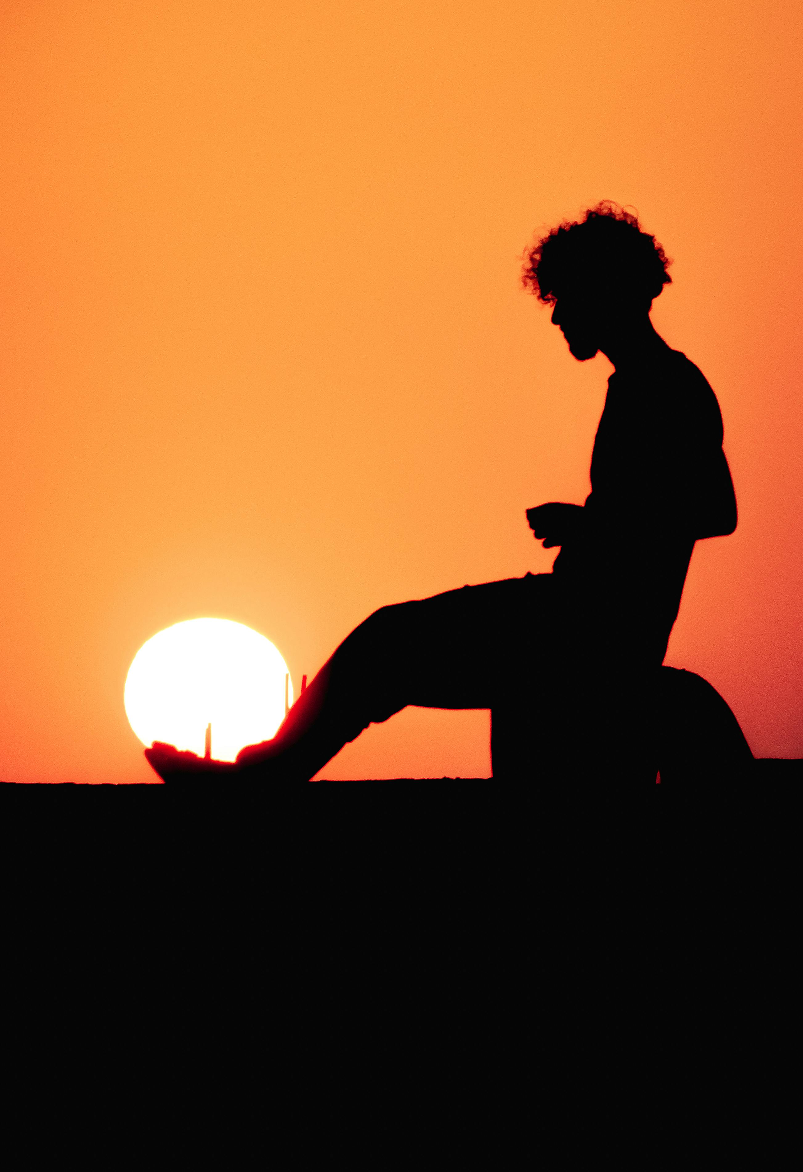 Cleanly defined silhouette of a male person turned to the left against a  yellow background with