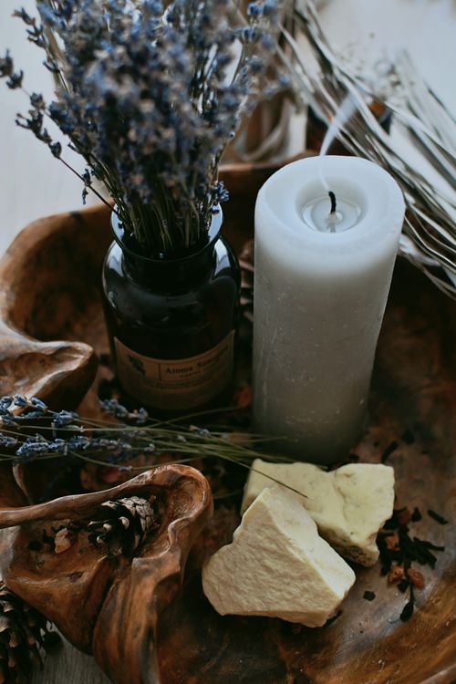 Free Warm rustic still life featuring a candle and dried lavender in a wooden bowl. Stock Photo