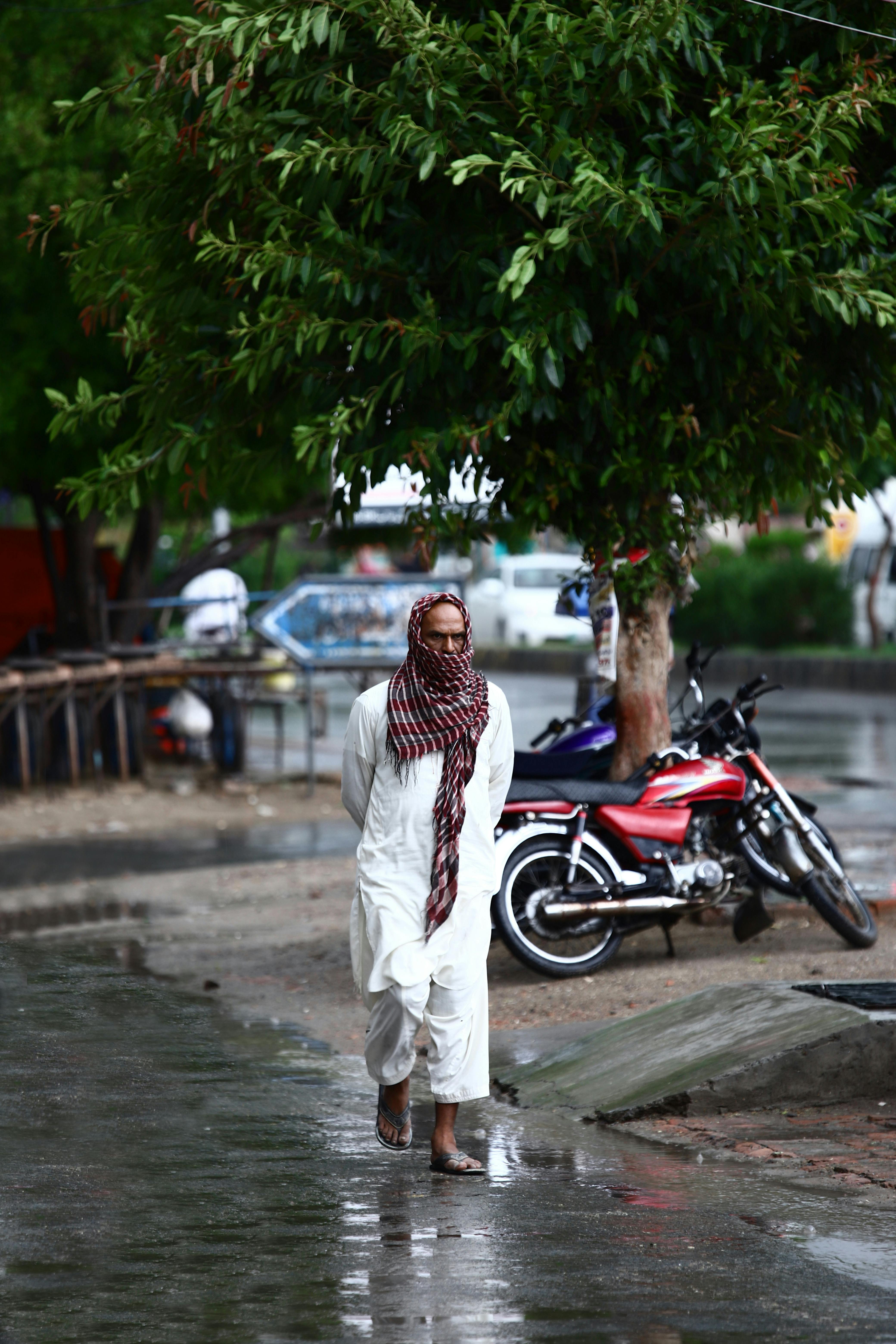 man wearing flip flops in rain in city