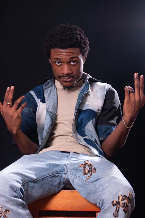 Free Portrait of a confident man gesturing in a stylish denim jacket against a black studio background. Stock Photo