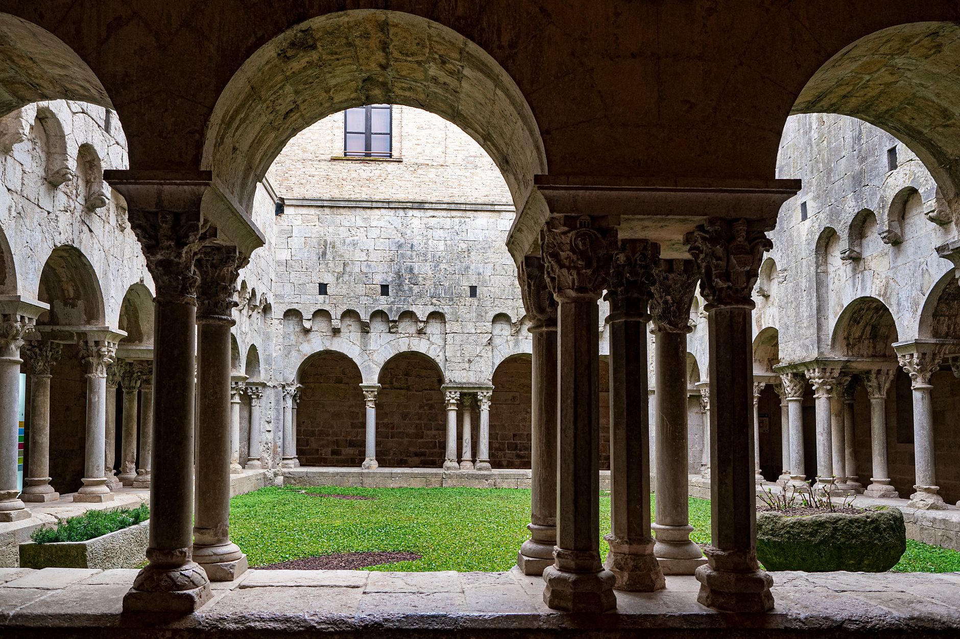 Tarragona Cathedral cloister Romanesque arcade with carved capitals and garden courtyard