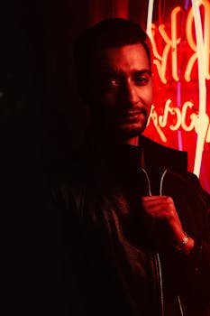 霓虹灯前，一位时尚男士摆出姿势，营造出喜怒无常的氛围