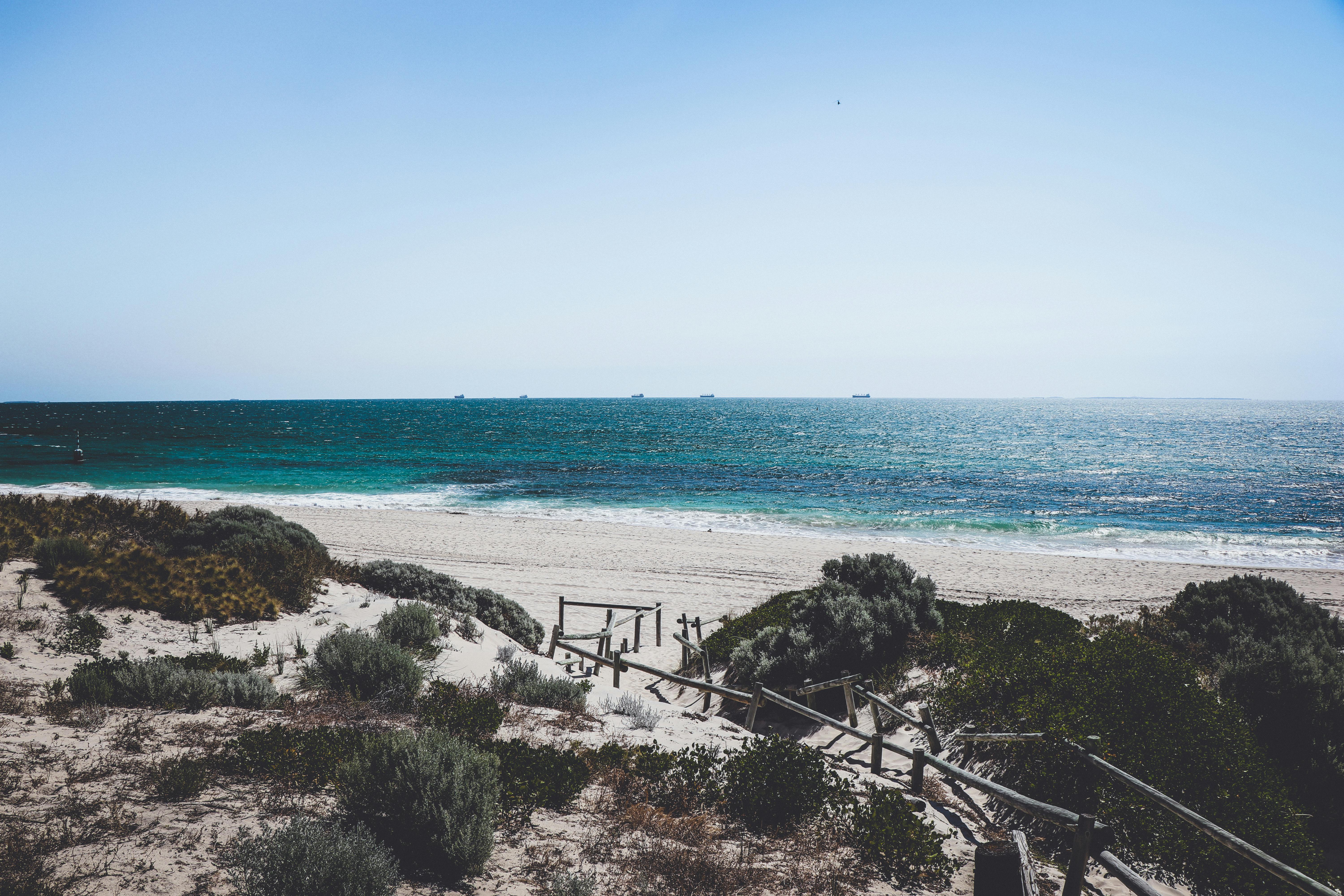 这片宁静的海滩拥有白色沙滩和深蓝色海浪，非常适合夏季旅行