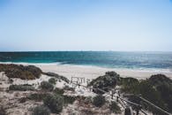 这片宁静的海滩拥有白色沙滩和深蓝色海浪，非常适合夏季旅行