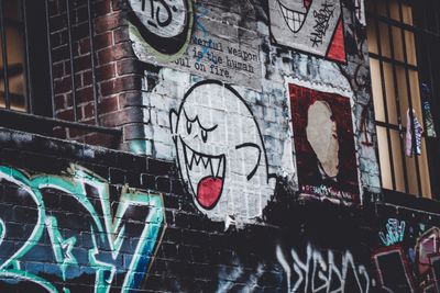 Character paste-up on a brick wall — photo by Hugo Heimendinger on Pexels