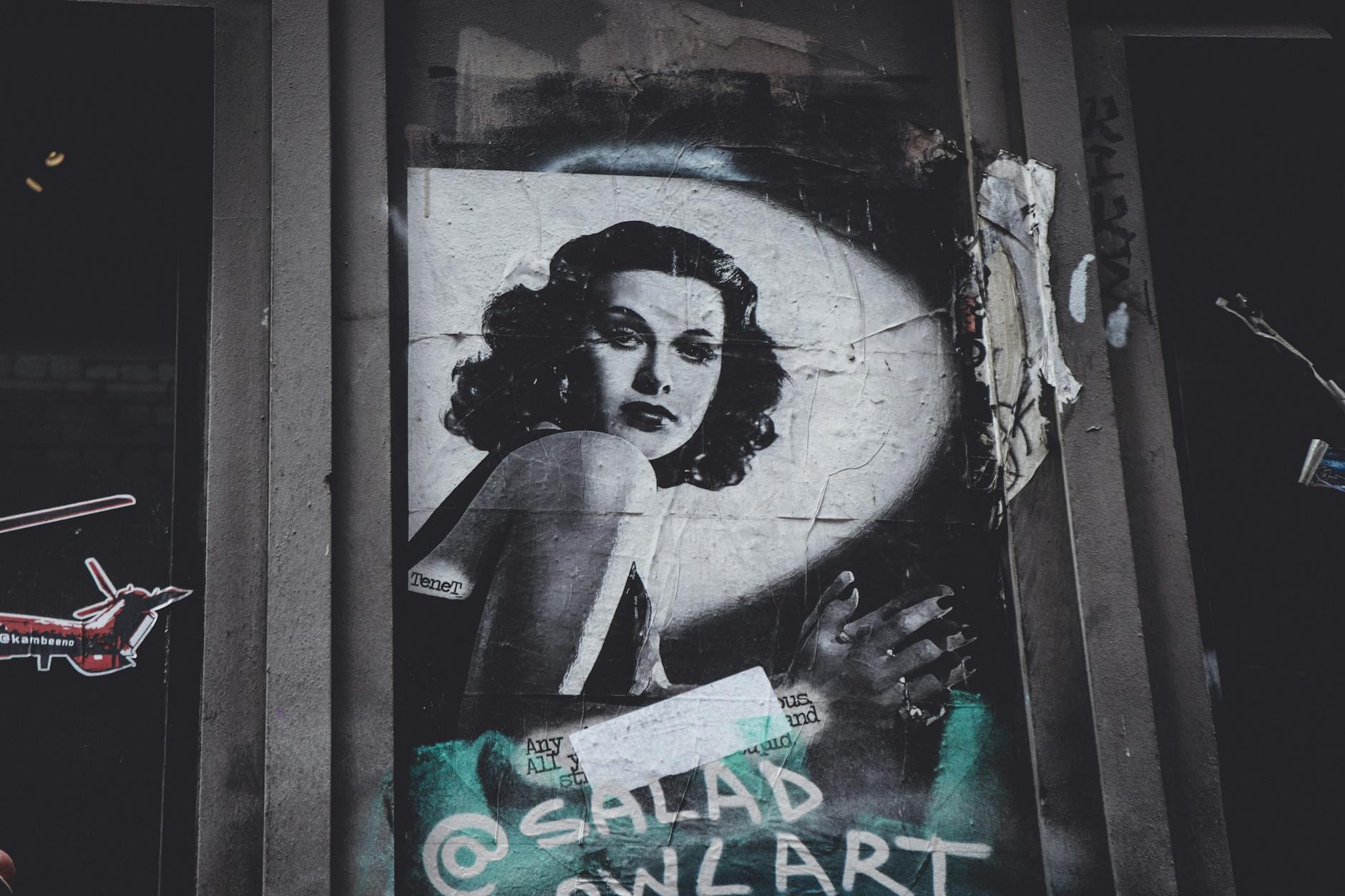 Artistic black and white street art portrait displayed on a city wall, showcasing vintage style.