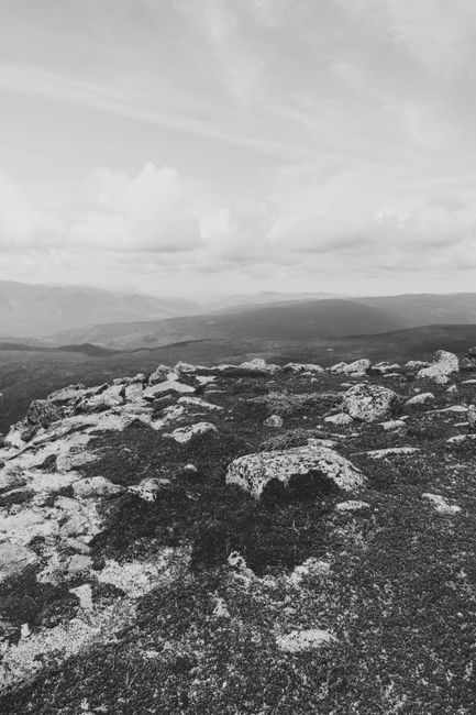 Monochrome landscape of a rocky mountainous region under cloudy skies.