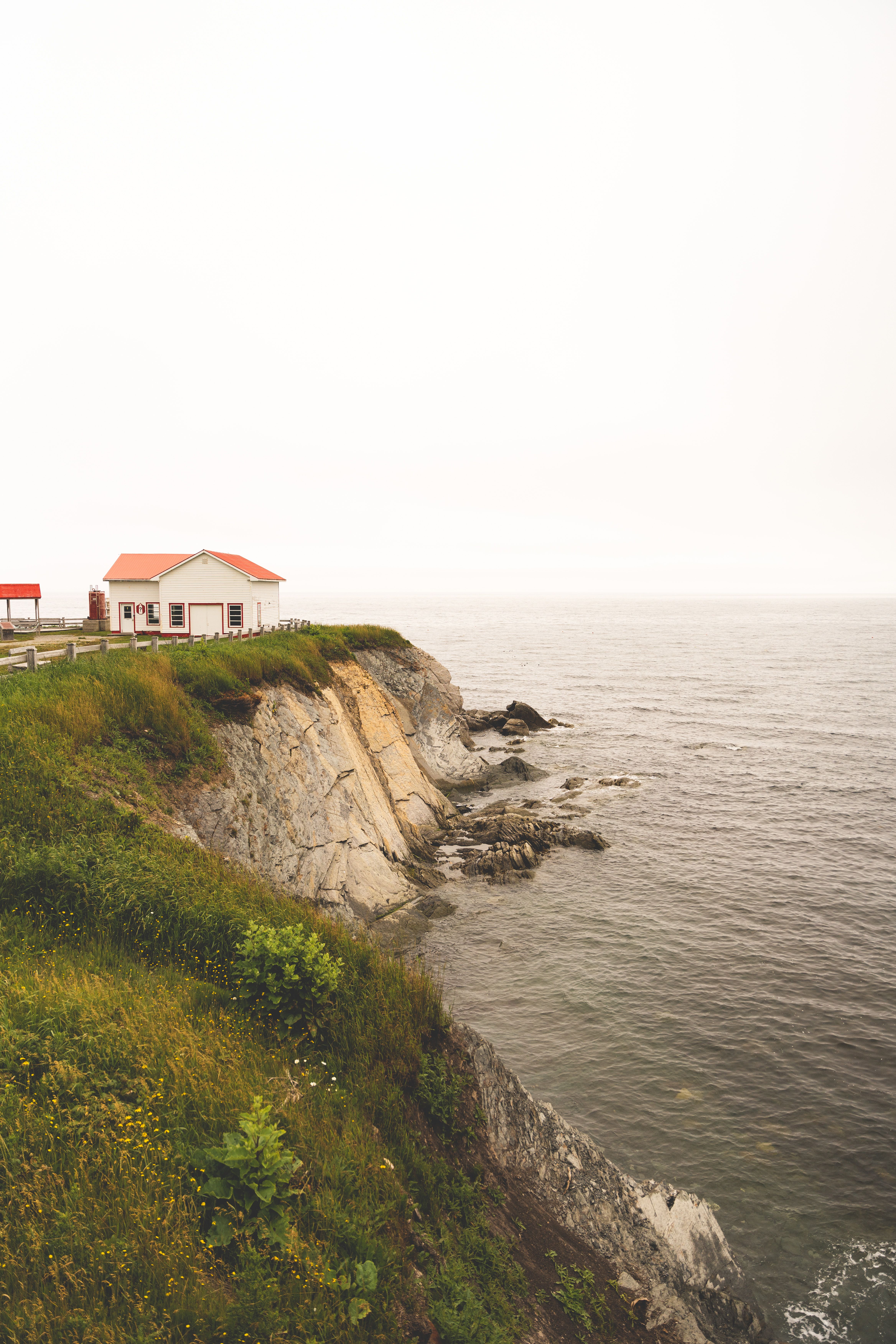 A house on the edge of a cliff overlooking the ocean · Free Stock Photo