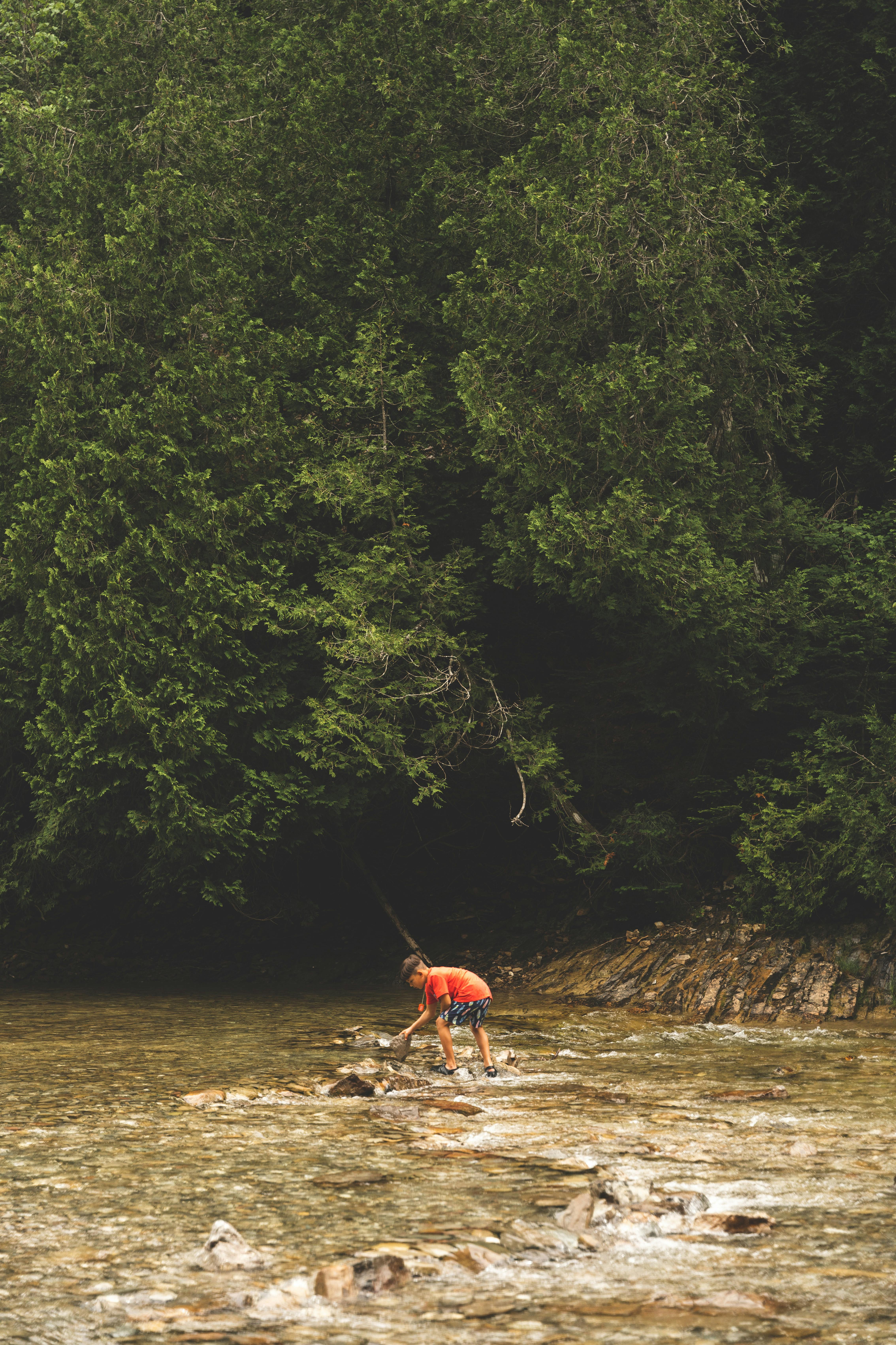 A person standing in the water with a fishing rod